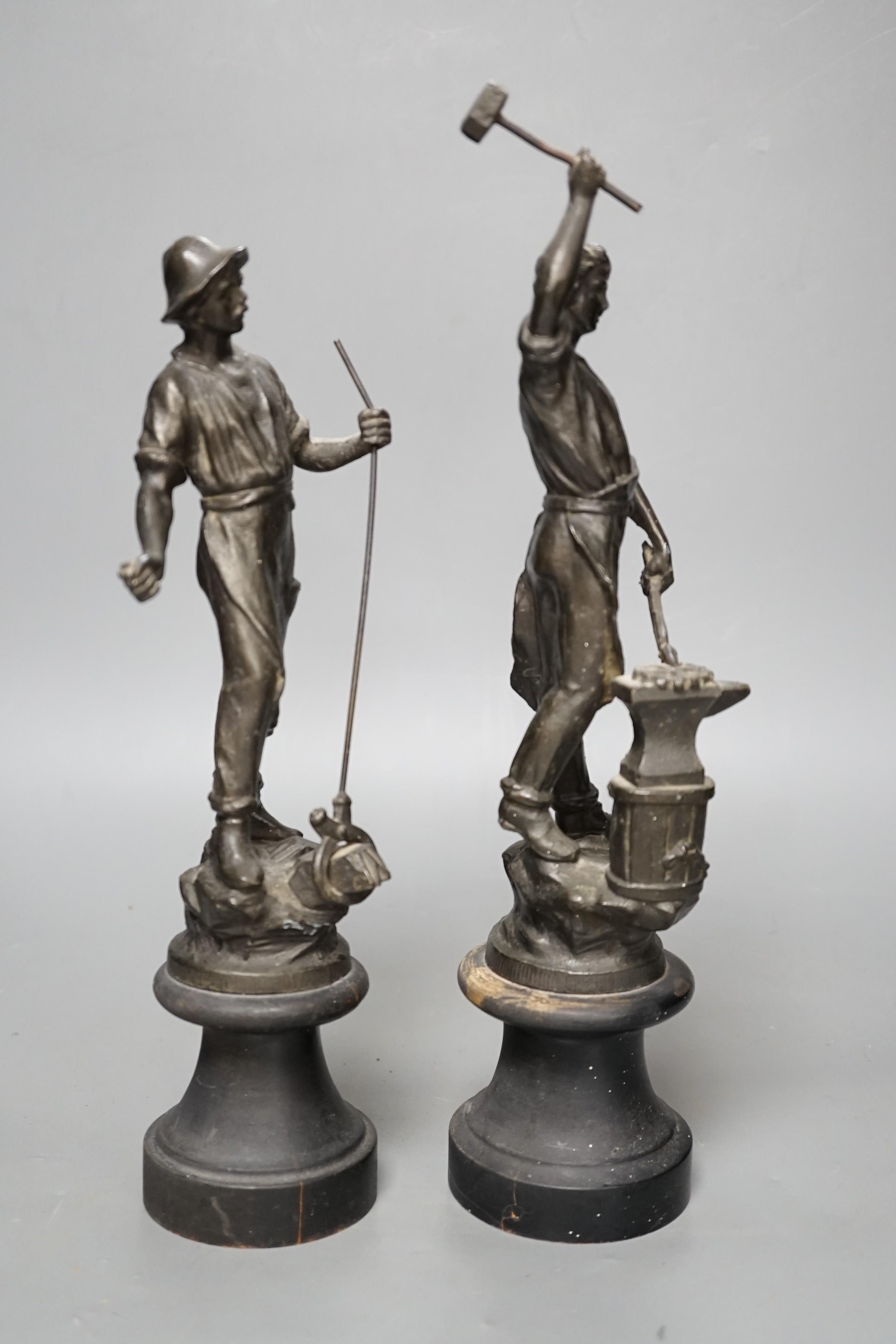 A pair of spelter blacksmith figures, tallest 34cms high